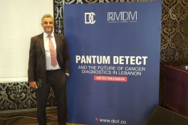 Dr Ahmed Bourghida next to Pantum Detect cancer diagnostics sign